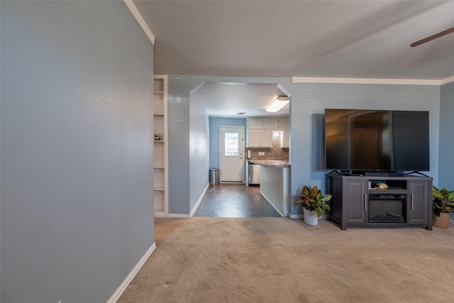 living area with a ceiling fan, baseboards, crown molding, and light colored carpet