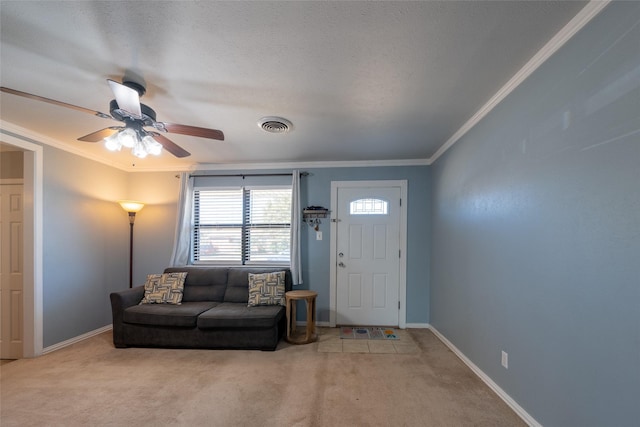 carpeted living room with baseboards, ceiling fan, visible vents, and crown molding