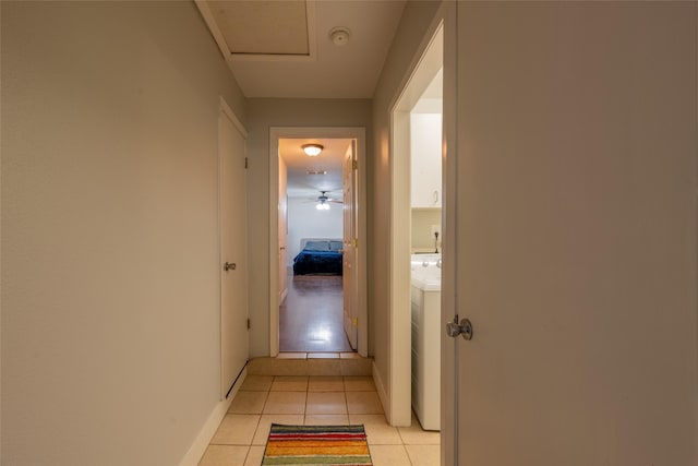 hall with washer / clothes dryer and light tile patterned flooring