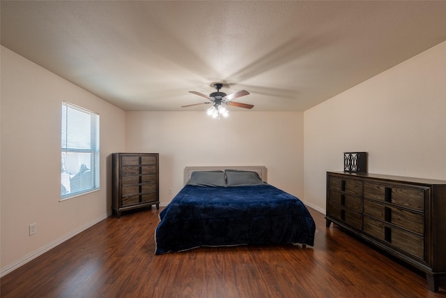 bedroom featuring a ceiling fan, baseboards, and wood finished floors