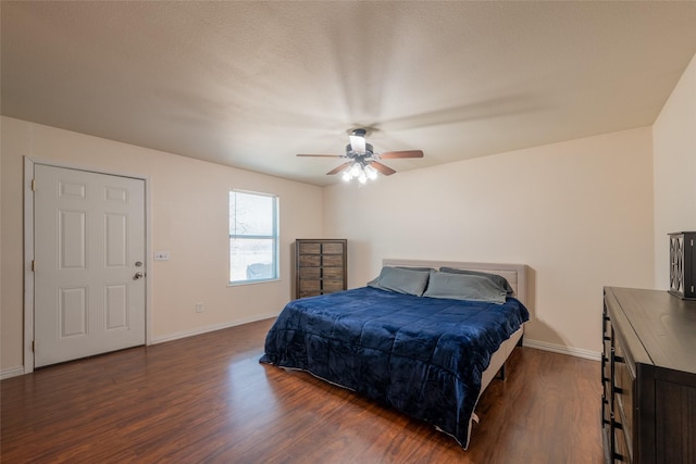 bedroom featuring dark wood finished floors, baseboards, and ceiling fan