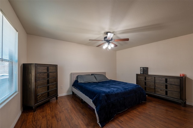 bedroom featuring ceiling fan, baseboards, and wood finished floors