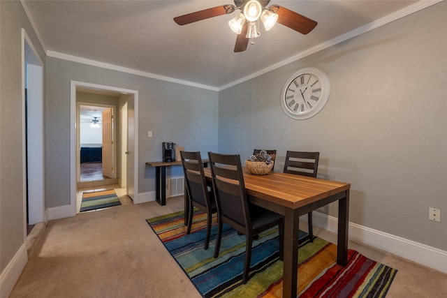 carpeted dining room with visible vents, crown molding, and baseboards