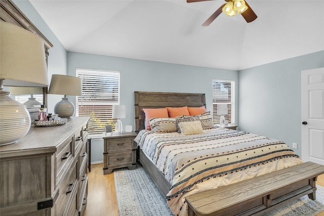 bedroom featuring ceiling fan, light wood-style flooring, and vaulted ceiling