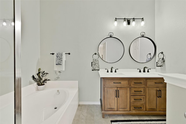 bathroom with a garden tub, double vanity, a sink, and baseboards