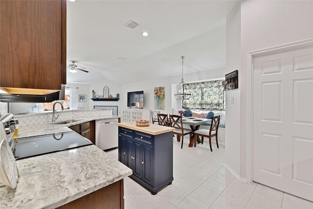 kitchen with lofted ceiling, stove, blue cabinets, stainless steel dishwasher, and a sink