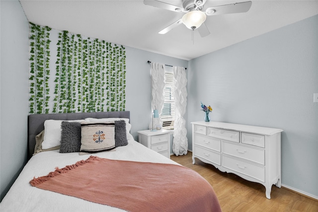 bedroom featuring a ceiling fan, baseboards, and light wood finished floors