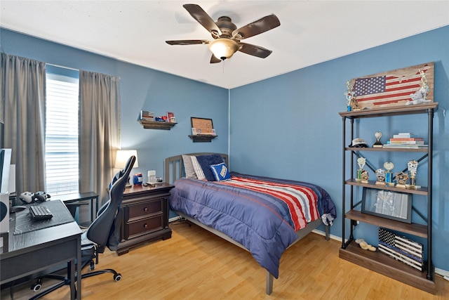 bedroom featuring wood finished floors, a ceiling fan, and baseboards