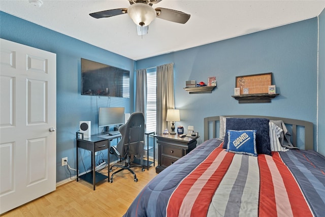 bedroom with a ceiling fan, baseboards, and wood finished floors