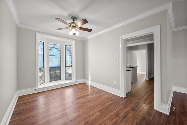 empty room featuring ornamental molding, dark wood finished floors, and ceiling fan