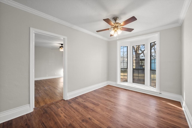 spare room featuring ornamental molding, wood finished floors, and baseboards