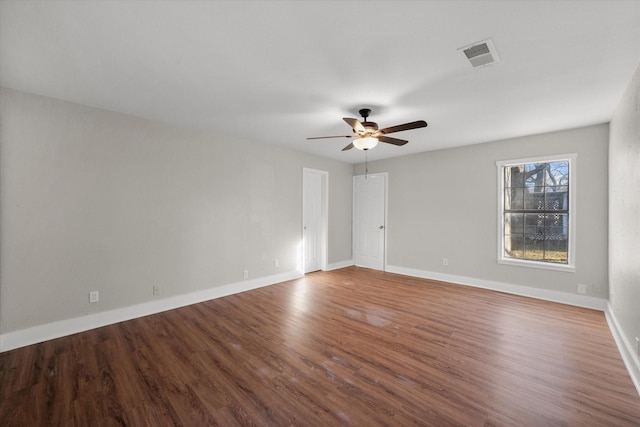 spare room featuring visible vents, ceiling fan, baseboards, and wood finished floors