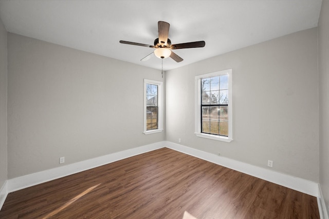 unfurnished room with a ceiling fan, dark wood-style flooring, and baseboards