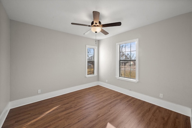 unfurnished room with ceiling fan, dark wood-type flooring, and baseboards