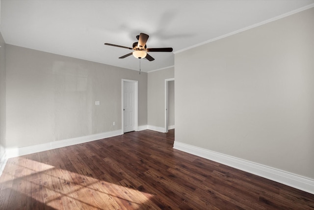 spare room featuring ornamental molding, dark wood-style flooring, ceiling fan, and baseboards