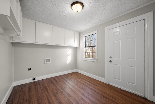 clothes washing area featuring cabinet space, baseboards, dark wood-type flooring, hookup for a washing machine, and electric dryer hookup