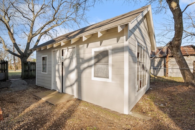 view of property exterior with fence and an outdoor structure