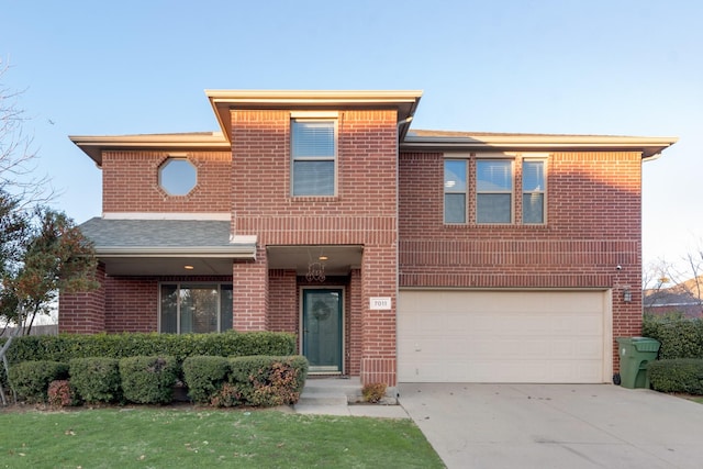 view of front of home featuring driveway, brick siding, and an attached garage