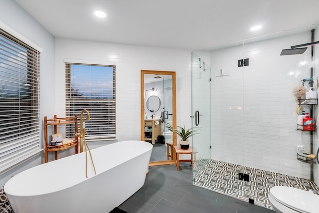 full bath featuring a stall shower, toilet, tile patterned flooring, a freestanding tub, and recessed lighting