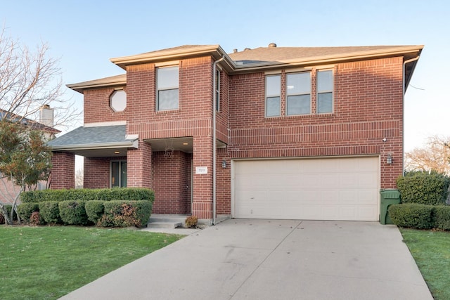 view of front facade featuring driveway, a front lawn, an attached garage, and brick siding