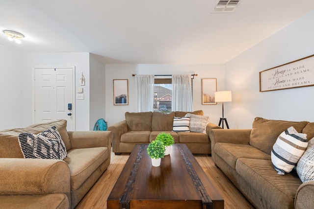 living area featuring light wood-type flooring and visible vents