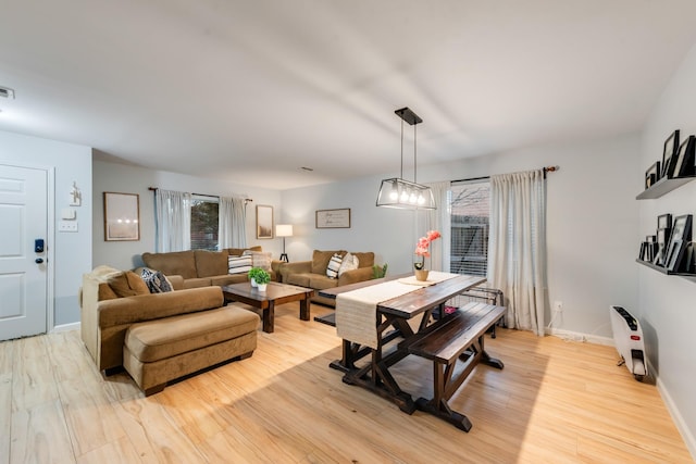 living room featuring baseboards, visible vents, a wealth of natural light, and light wood-style floors