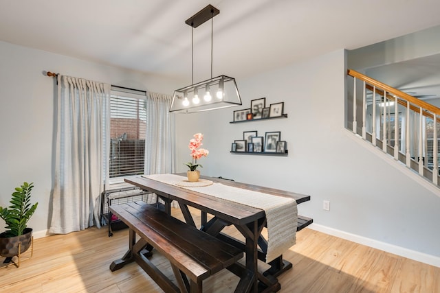 dining area with stairway, baseboards, and wood finished floors