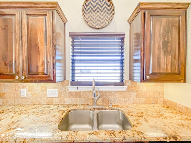 kitchen featuring a sink and light stone countertops