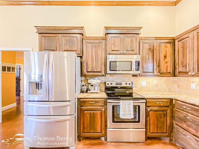 kitchen with brown cabinets, appliances with stainless steel finishes, backsplash, and light stone countertops