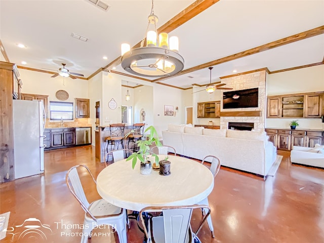 dining space featuring concrete flooring, ceiling fan with notable chandelier, and visible vents