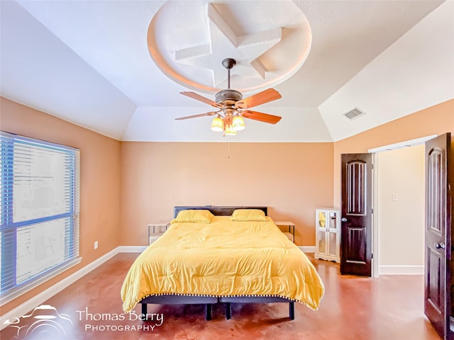 bedroom with baseboards, visible vents, vaulted ceiling, and a tray ceiling