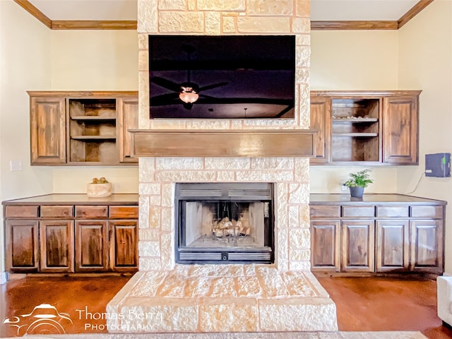 living room featuring ornamental molding and a fireplace with raised hearth