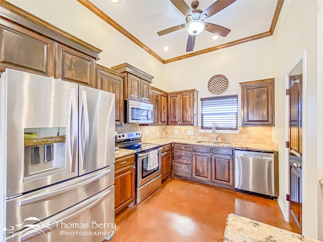 kitchen featuring tasteful backsplash, appliances with stainless steel finishes, light stone counters, finished concrete floors, and a sink