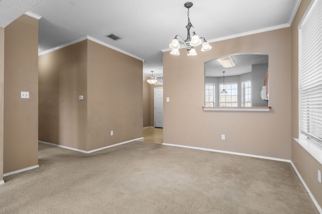 spare room with baseboards, carpet flooring, visible vents, and crown molding