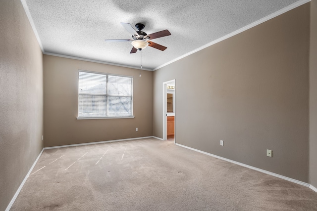 spare room with light carpet, baseboards, ornamental molding, and a textured ceiling