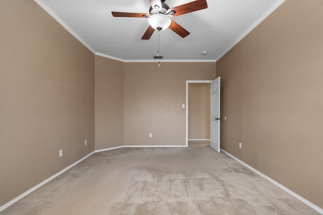 unfurnished room with a textured ceiling, baseboards, crown molding, and light colored carpet