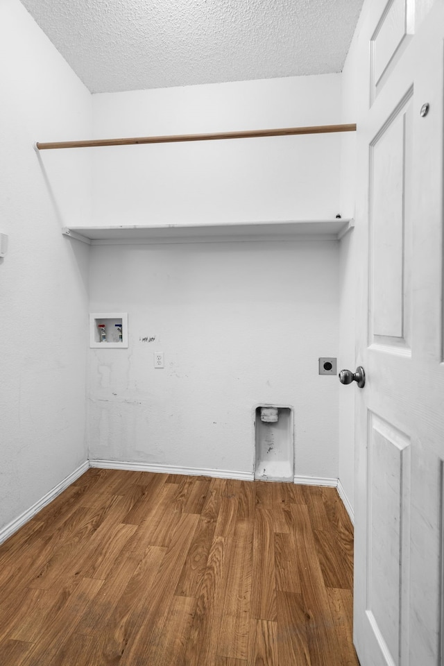 laundry room featuring laundry area, wood finished floors, hookup for a washing machine, a textured ceiling, and hookup for an electric dryer