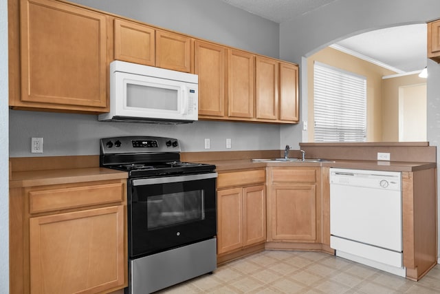 kitchen with arched walkways, a peninsula, white appliances, a sink, and light floors