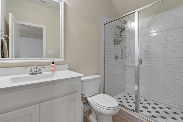 bathroom with tile patterned flooring, toilet, visible vents, vanity, and a shower stall