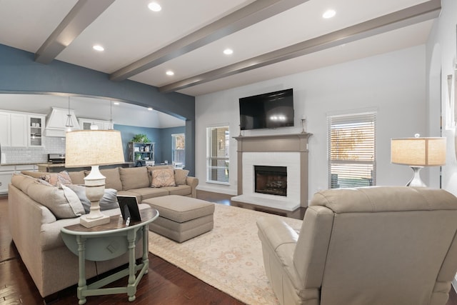 living area with a fireplace, dark wood-type flooring, beamed ceiling, and recessed lighting