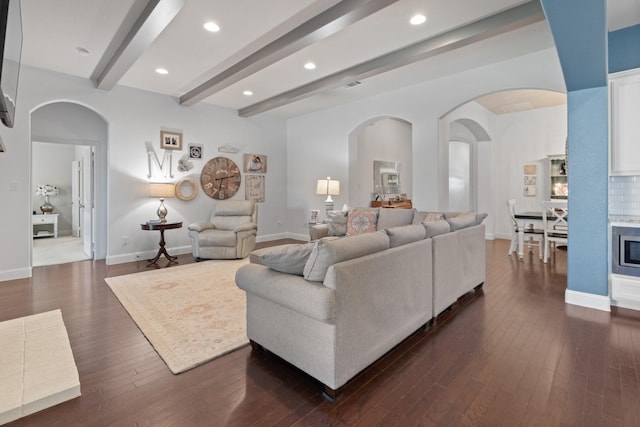 living area with arched walkways, beam ceiling, recessed lighting, dark wood-type flooring, and baseboards