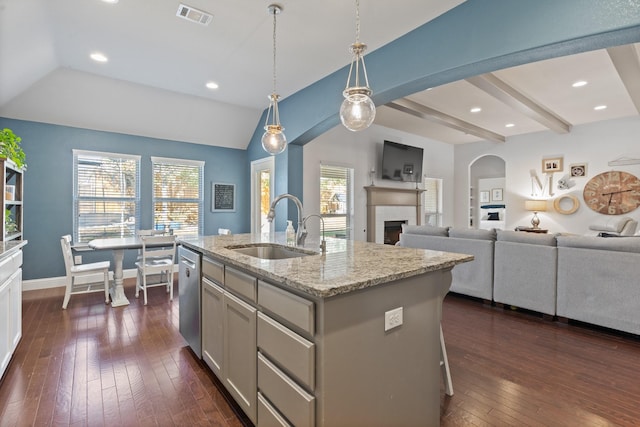 kitchen with visible vents, dark wood finished floors, hanging light fixtures, a sink, and stainless steel dishwasher