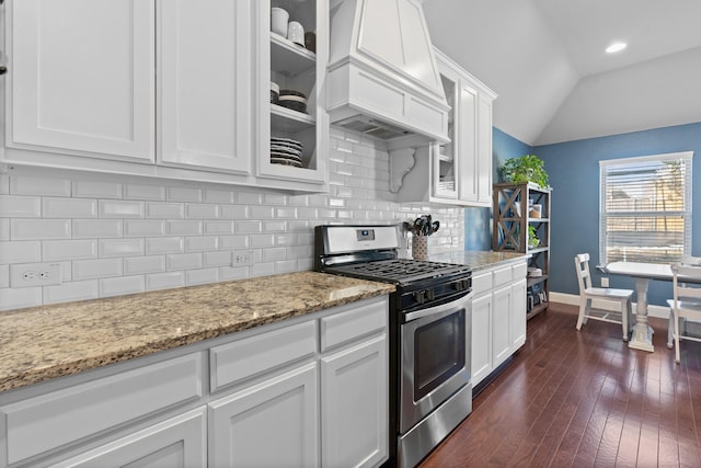 kitchen with lofted ceiling, white cabinetry, stainless steel gas range, decorative backsplash, and custom range hood