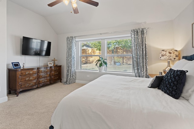 bedroom featuring lofted ceiling, baseboards, carpet floors, and a ceiling fan