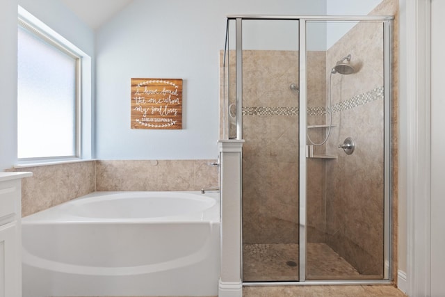 full bathroom featuring vaulted ceiling, a stall shower, vanity, and a bath