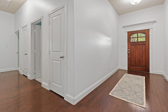 foyer featuring dark wood-style floors, baseboards, and visible vents