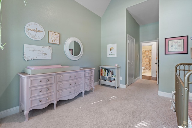 bedroom with light carpet, vaulted ceiling, ensuite bath, and baseboards