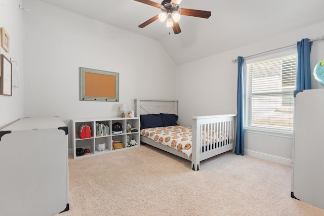 bedroom featuring carpet floors, vaulted ceiling, baseboards, and a ceiling fan