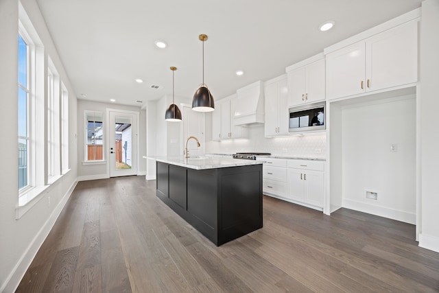 kitchen featuring custom range hood, backsplash, dark wood-type flooring, white cabinets, and built in microwave