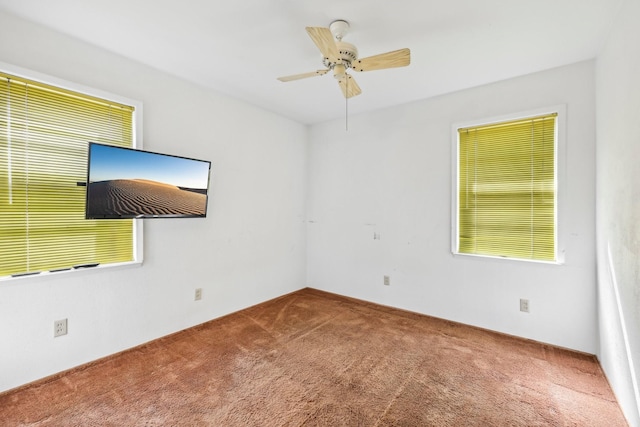 carpeted empty room with a ceiling fan